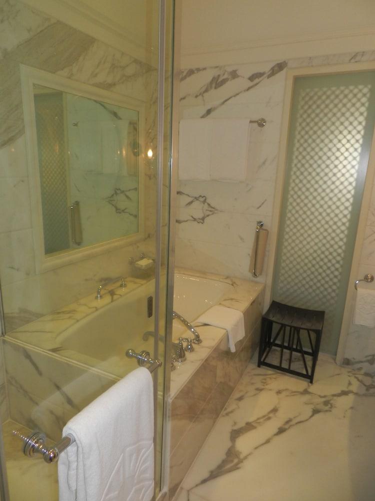 The Taj Mahal Tower, Mumbai Hotel Kültér fotó The photo displays a bathroom featuring a luxurious design. There is a glass-enclosed shower area alongside a large bathtub. The walls are adorned with marble, giving a sophisticated look. A few white towels are neatly arranged, and there is a small 