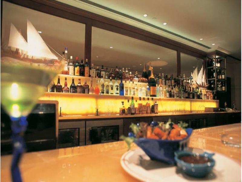 The Taj Mahal Tower, Mumbai Hotel Kültér fotó The photo depicts a stylish bar setting. In the background, there is a well-stocked bar shelf lined with numerous bottles of various alcoholic beverages, illuminated by soft lighting that creates a warm ambiance. The countertop appears to be smooth a
